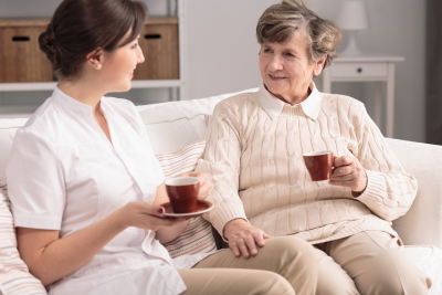 senior woman and caregiver having a cup of tea